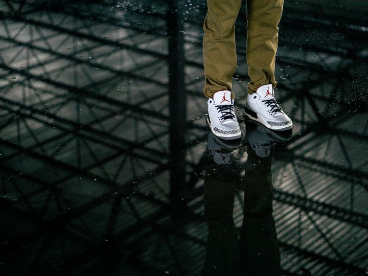 A pair of Air Jordan sneakers reflected on a glossy surface