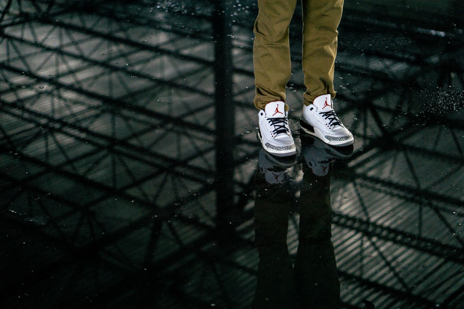 A pair of Air Jordan sneakers reflected on a glossy surface
